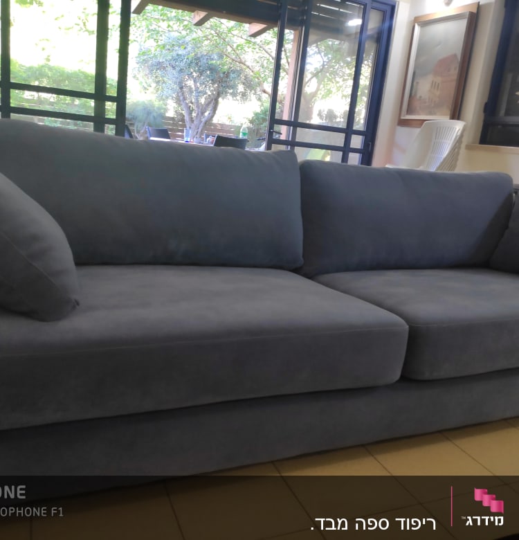 ספה כחולה עם כריות מרופדות בסלון מואר